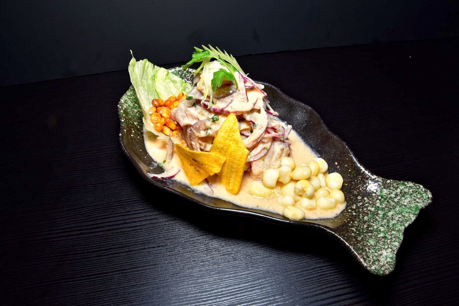 Ceviche de corvina acompañado de maíz choclo. maíz tostado y frituras de plátano.